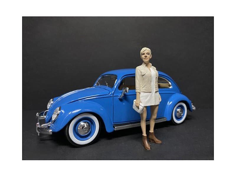 Vintage Blue Car with Woman Figurine Vintage blue toy car with a detailed female figurine standing beside it.