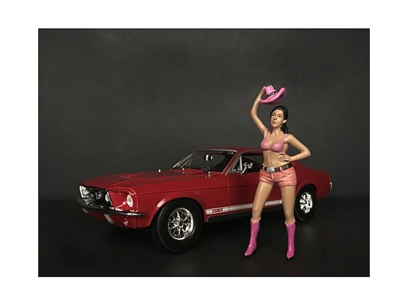 Classic Red Muscle Car with Fashionable Woman Figurine Vintage red muscle car with a stylish woman figurine holding a pink cowboy hat.