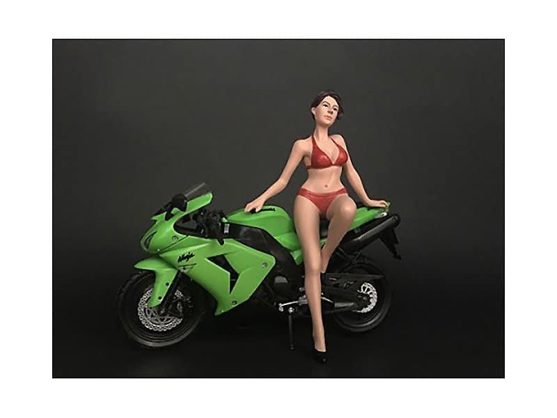 Sporty green motorcycle with a female mannequin in red lingerie. A green sport motorcycle with a female mannequin dressed in red lingerie, set against a dark backgro.